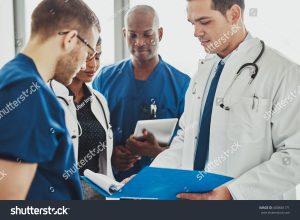 medcare vacances - stock photo doctors having a conversation looking at documents mixed races surgeons and doctors 400846171